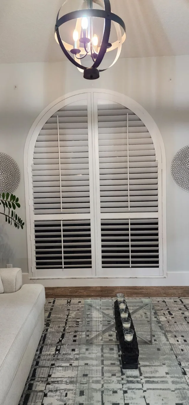 Custom-fit plantation shutters on an arched window — precision installation by Seaglass Window Fashions