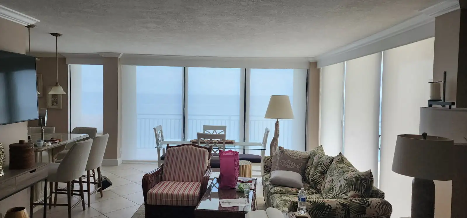 Roller shades installed in an oceanfront condo living room with panoramic ocean views in Palm Beach County