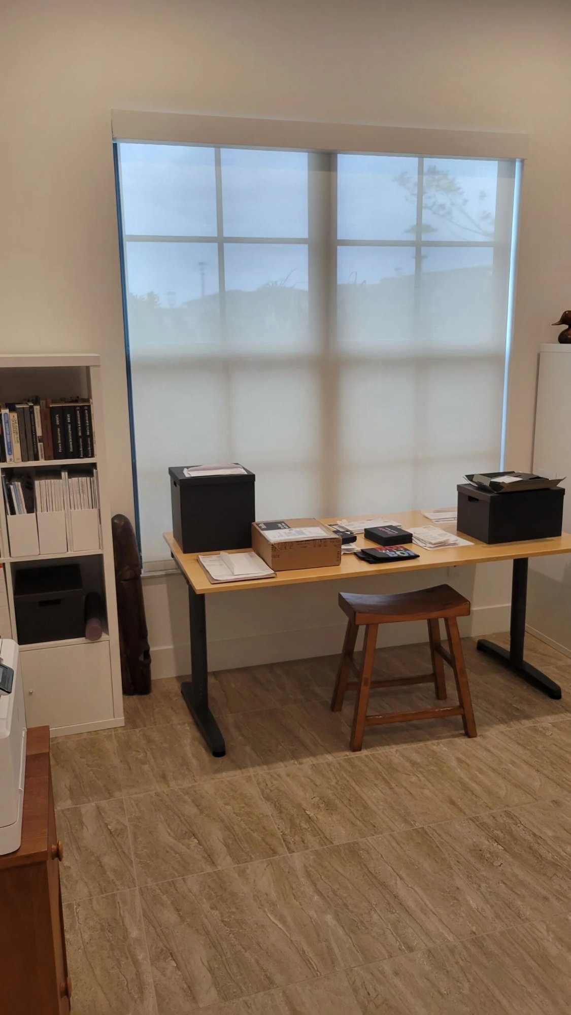 Solar roller shade filtering light in a home office with standing desk